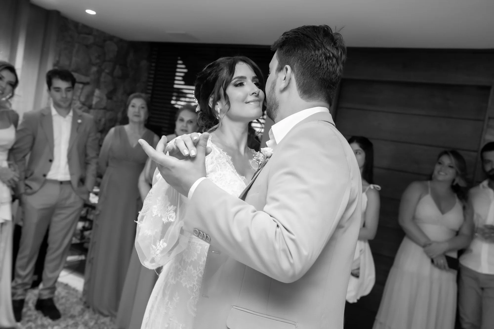 Casal dança cercado pelos convidados, em fotografia em preto e branco